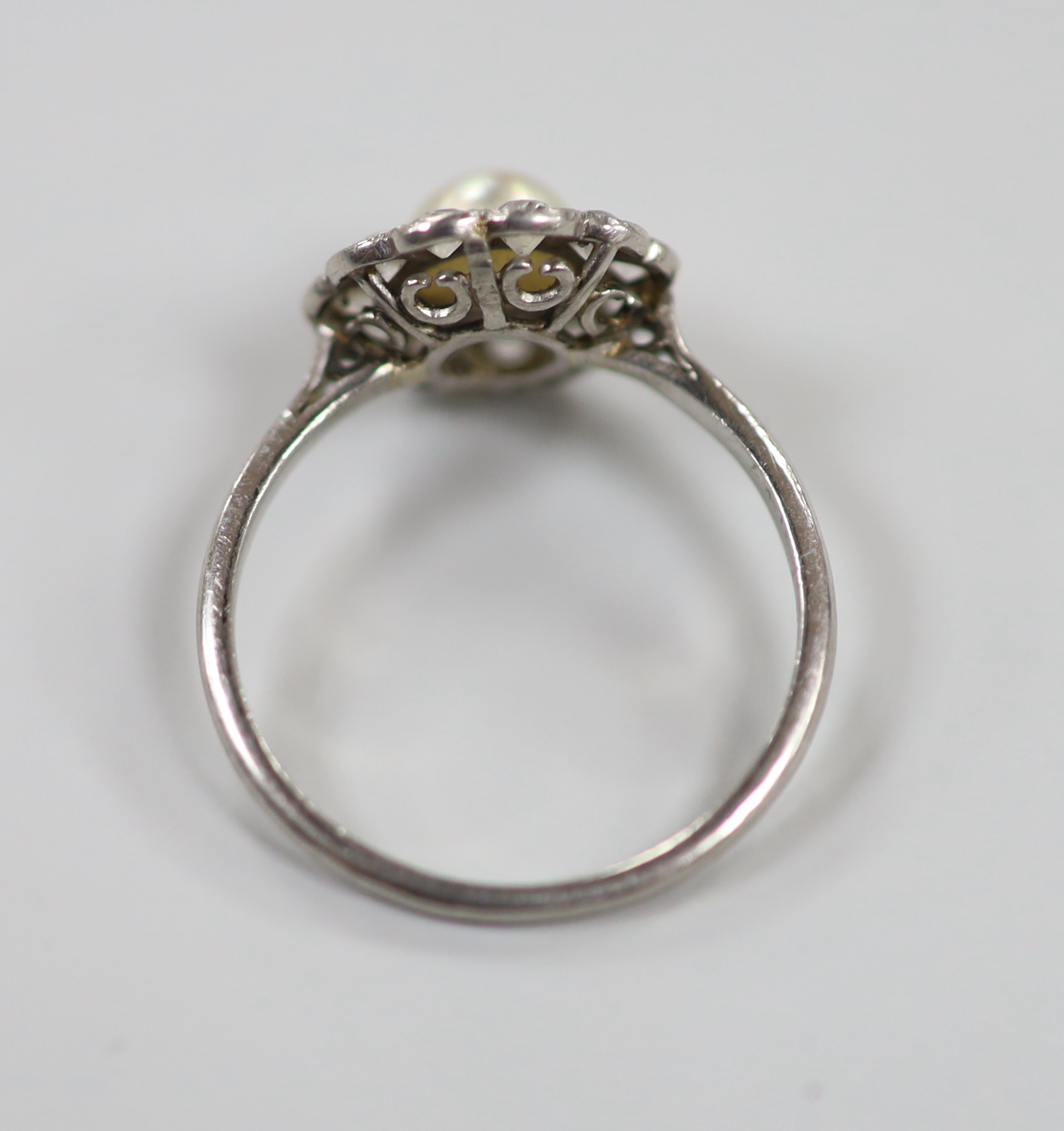 A 1920's white metal, cultured pearl and diamond set circular cluster ring, size M/N, gross weight 3.3 grams.